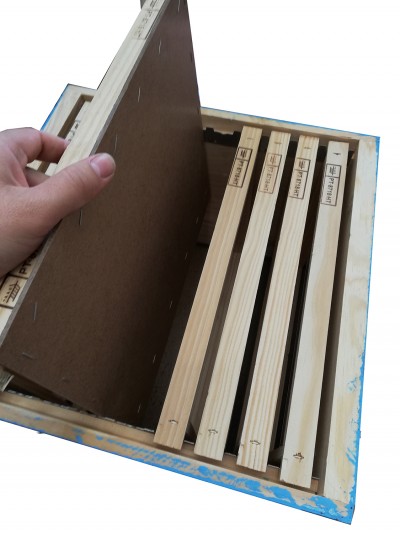 Caixa de madeira com quadros e painel castanho escuro, mão a segurar