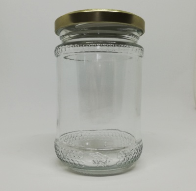 Frasco de vidro transparente com tampa dourada e textura circular