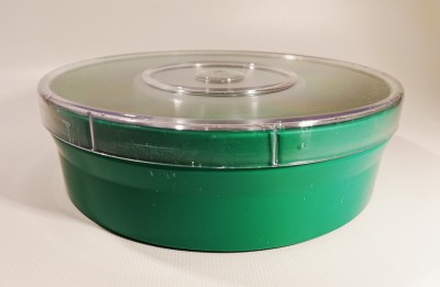 Embalagem redonda verde com tampa translúcida sobre superfície branca