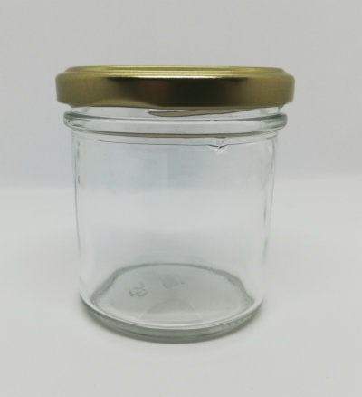 Frasco de vidro transparente com tampa metálica dourada sobre fundo branco