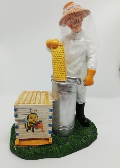 Estátua de apicultor com colmeia e quadro de mel sobre base verde