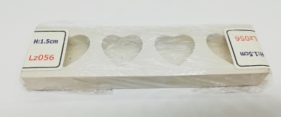 Suporte branco para velas com recortes em forma de coração em madeira.