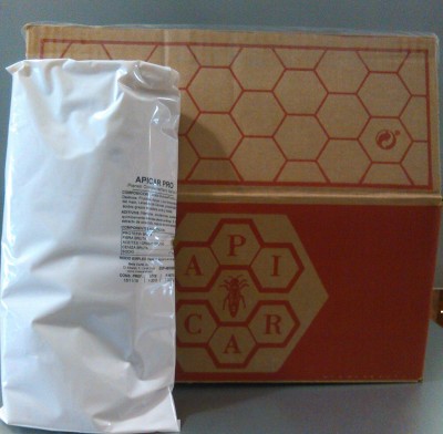 Embalagens com logotipo APICAR e padrão hexagonal em cartão castanho e saco branco