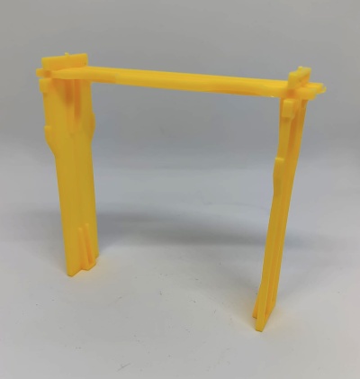 Suporte amarelo de plástico com estrutura simples colocado sobre superfície branca