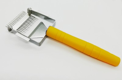 Raspador de lã amarelo com lâminas metálicas em fundo branco