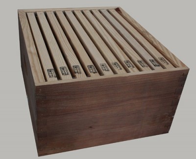 Caixa de madeira castanha com divisórias de ripas claras e etiquetas numeradas