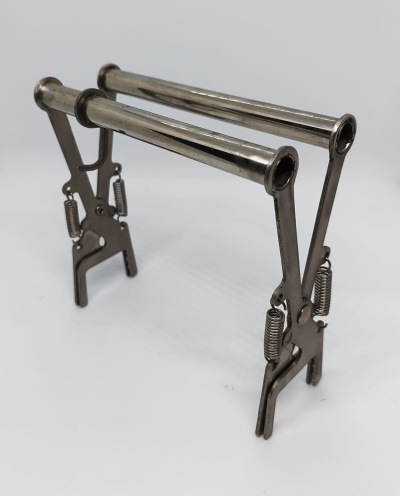 Suporte metálico prateado com presilhas e molas sobre fundo branco