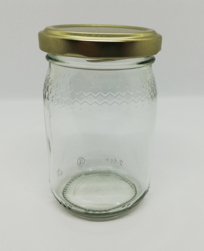 Frasco de vidro transparente com tampa dourada e textura em relevo