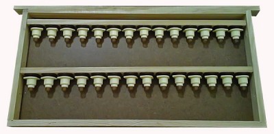 Moldura com duas fileiras de objetos cónicos brancos em base castanha.