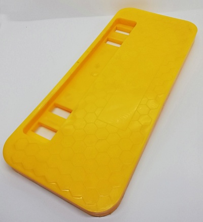 Base de plástico amarela com padrão hexagonal e recortes retangulares