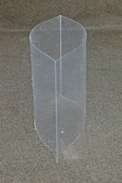 Estrutura plástica transparente cónica sobre superfície cinzenta