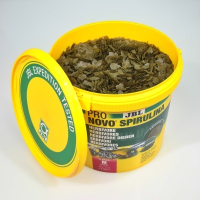 Baldes amarelo aberto com flocos verdes e rótulo JBL PRO NOVO SPIRULINA para herbívoros