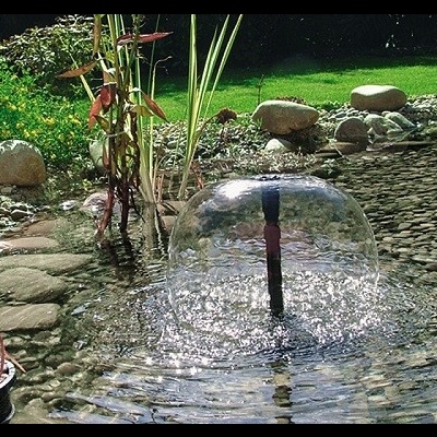 Fonte de água circular num lago de jardim com pedras e plantas