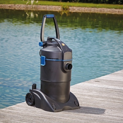 Bomba de água preta com alça azul sobre cais de madeira junto à água