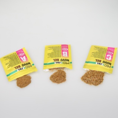 Três pequenos sacos amarelos abertos com alimento granulado visível em fundo branco