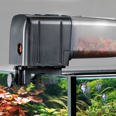 Alimentador automático de peixes preto montado em aquário com plantas e peixes