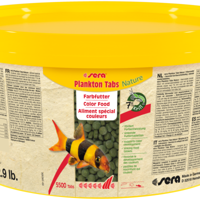 Recipiente amarelo com tabletes verdes para alimentação de peixes e etiquetas multilíngues.