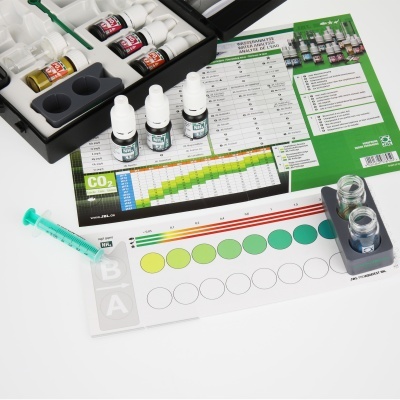 Kit de teste de água com frascos, syringa, tabela de cores e caixas pretas sobre fundo branco