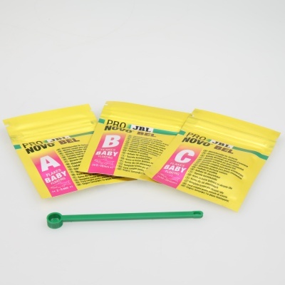 Três pacotes pequenos amarelos etiquetados A, B e C e uma espátula verde