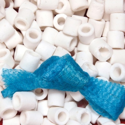 Pequenas peças cilíndricas brancas com rede azul trançada