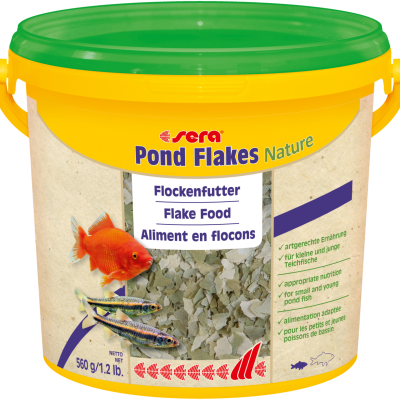 Recipiente amarelo de plástico com tampa verde e etiqueta com imagens de peixes e texto sobre alimento em flocos.