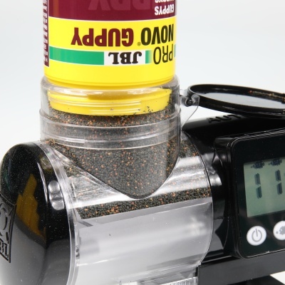 Pulverizador automático preto com sementes e frasco amarelo rotulado