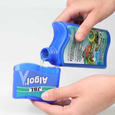 Frasco e medidor azuis com texto e rótulos, líquido a ser despejado.