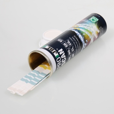 Tubo preto aberto com tiras de teste de água coloridas e tampas brancas ao fundo