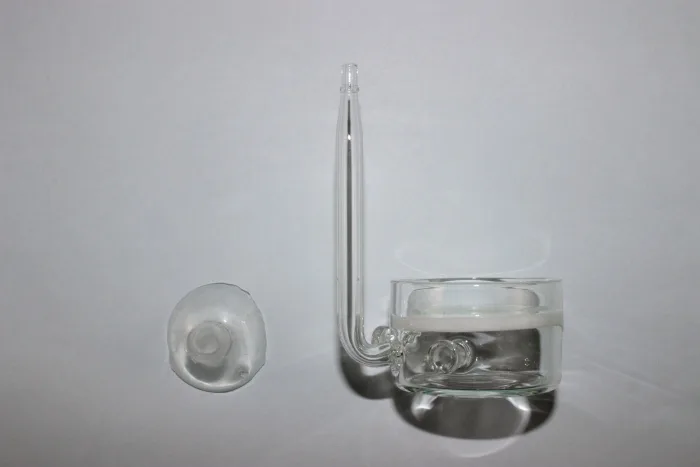 Produto em vidro transparente com corpo cilíndrico e tubo em forma de L