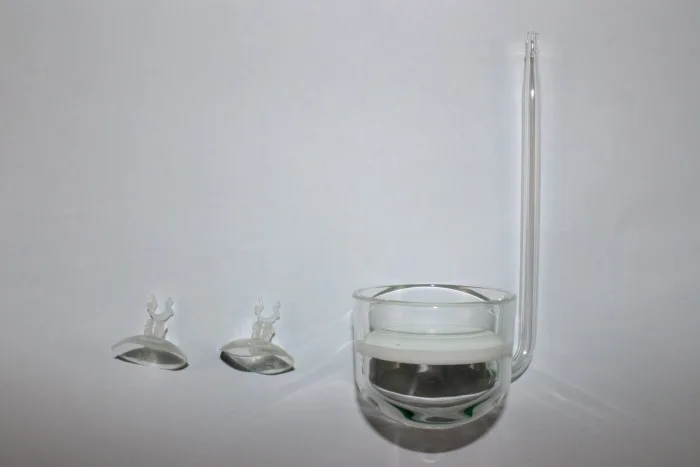 equipamento de vidro transparente com recipiente redondo, base branca e tubo longo, mais duas ventosas de plástico