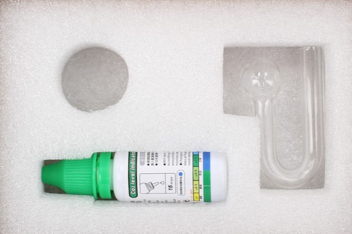 Kit de teste de CO2 com frasco plástico branco e tampa verde e acessórios transparentes em espuma branca
