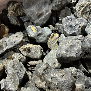 AD Pedras Hakkai kg Pedras cinzentas irregulares com manchas amarelas empilhadas.