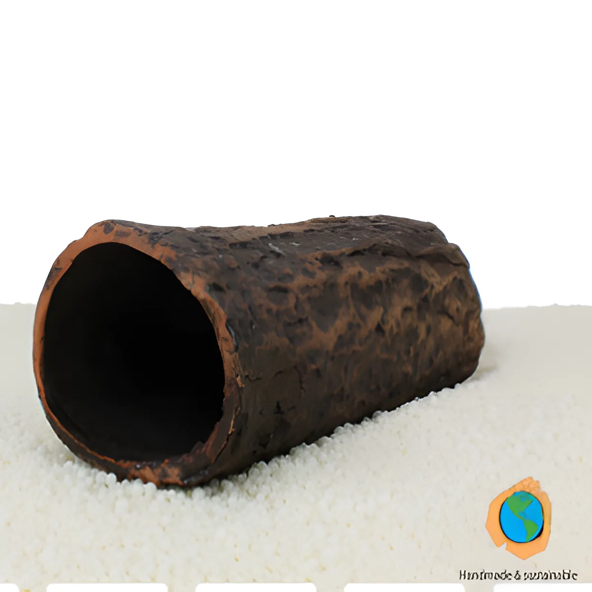 Objeto cilíndrico oco castanho escuro com textura rústica sobre superfície branca
