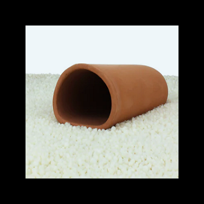 Vaso oval de cerâmica castanho claro sobre pequenas esferas brancas.