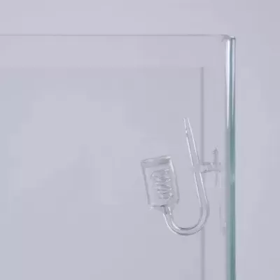 Acessório de vidro transparente com tubo em U e bobina, fixado à aresta de um recipiente de vidro maior