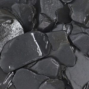 Pedras pretas lisas e brilhantes em superfície irregular