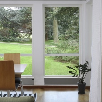 sala de jantar com mesas e cadeiras junto a janelas grandes