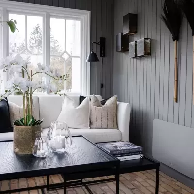 Sala de estar com sofá branco e mesa de centro preta com decoração