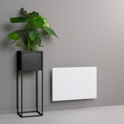 Radiador branco na parede cinzenta com planta verde em vaso preto ao lado