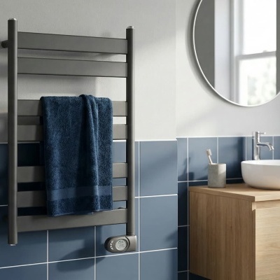 Radiador de toalhas metálico com toalha azul em casa de banho moderna.