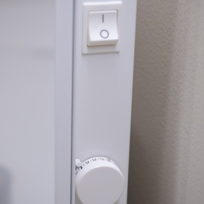 Interruptor branco com botão regulador numérico numa parede cinzenta