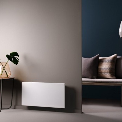 radiador elétrico branco na parede cinza com mesa de apoio e banco com almofadas