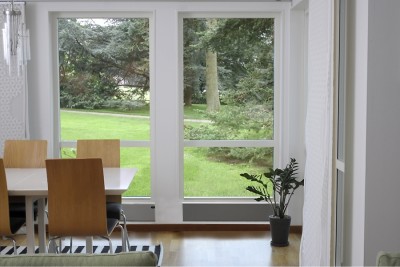 sala de jantar com mesas e cadeiras junto a janelas grandes