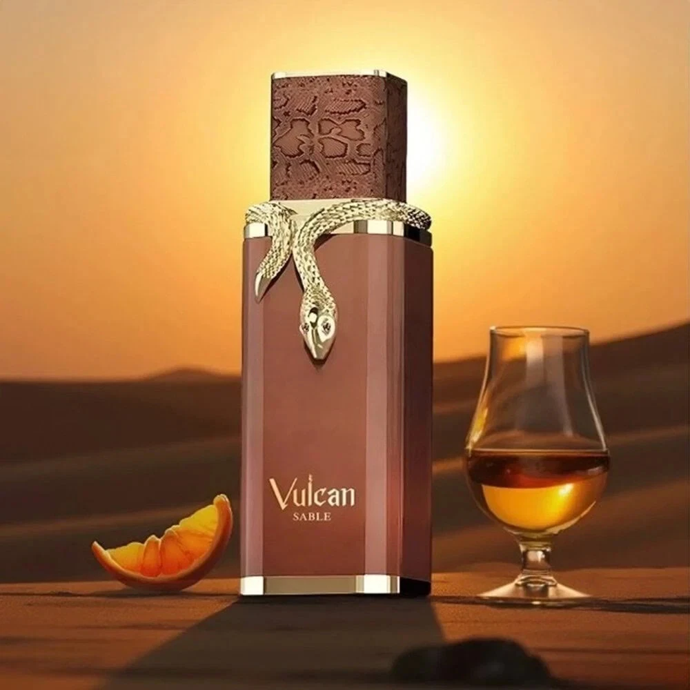 Frasco de perfume Vulcan SABLE com decoração de cobra e elementos de bebida e laranja em fundo de pôr do sol