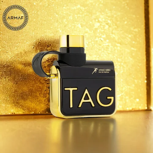 Frasco de perfume preto e dourado com texto TAG em relevo dourado sobre fundo dourado