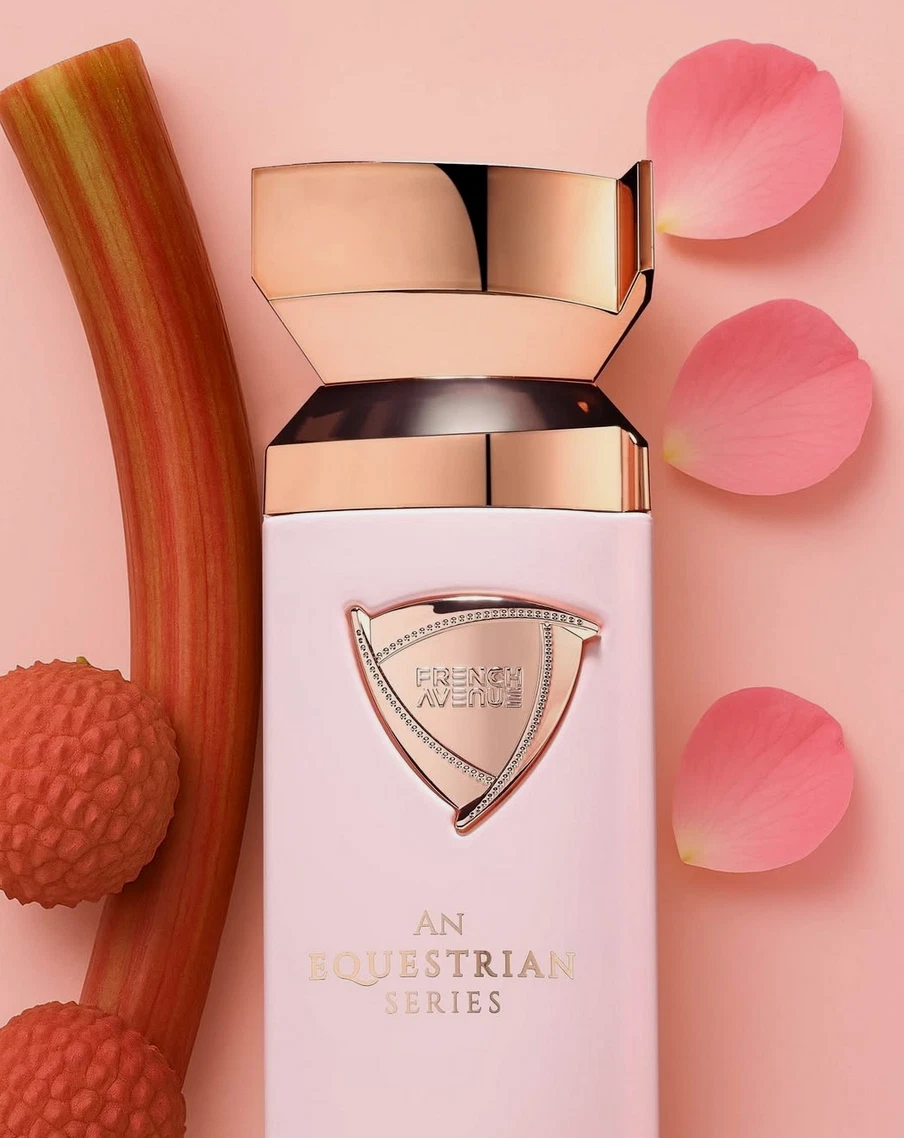 Frasco de perfume rosa claro com tampa dourada e texto decorativo com elementos naturais rosa