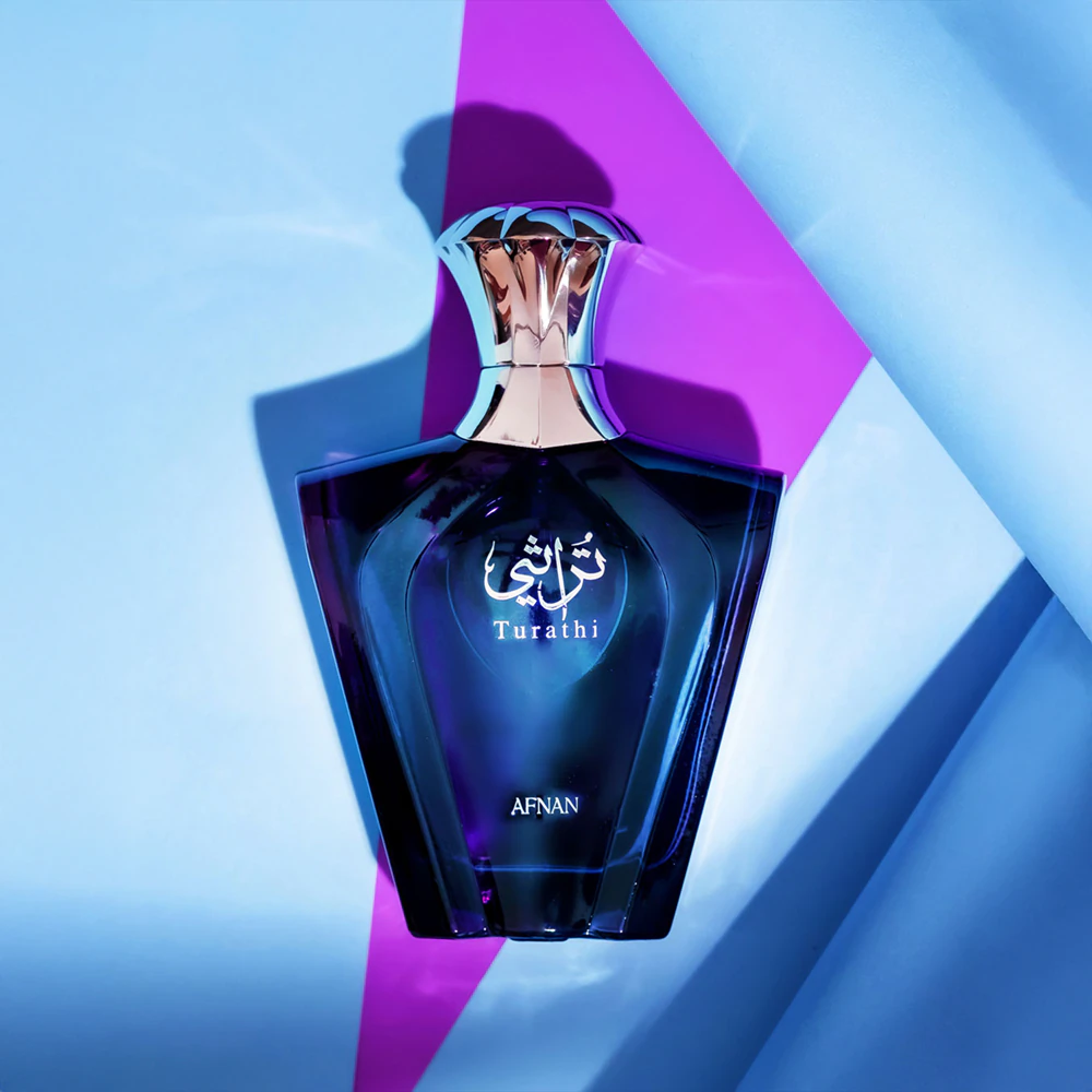 Frasco de perfume azul escuro com tampa prateada em fundo azul e roxo