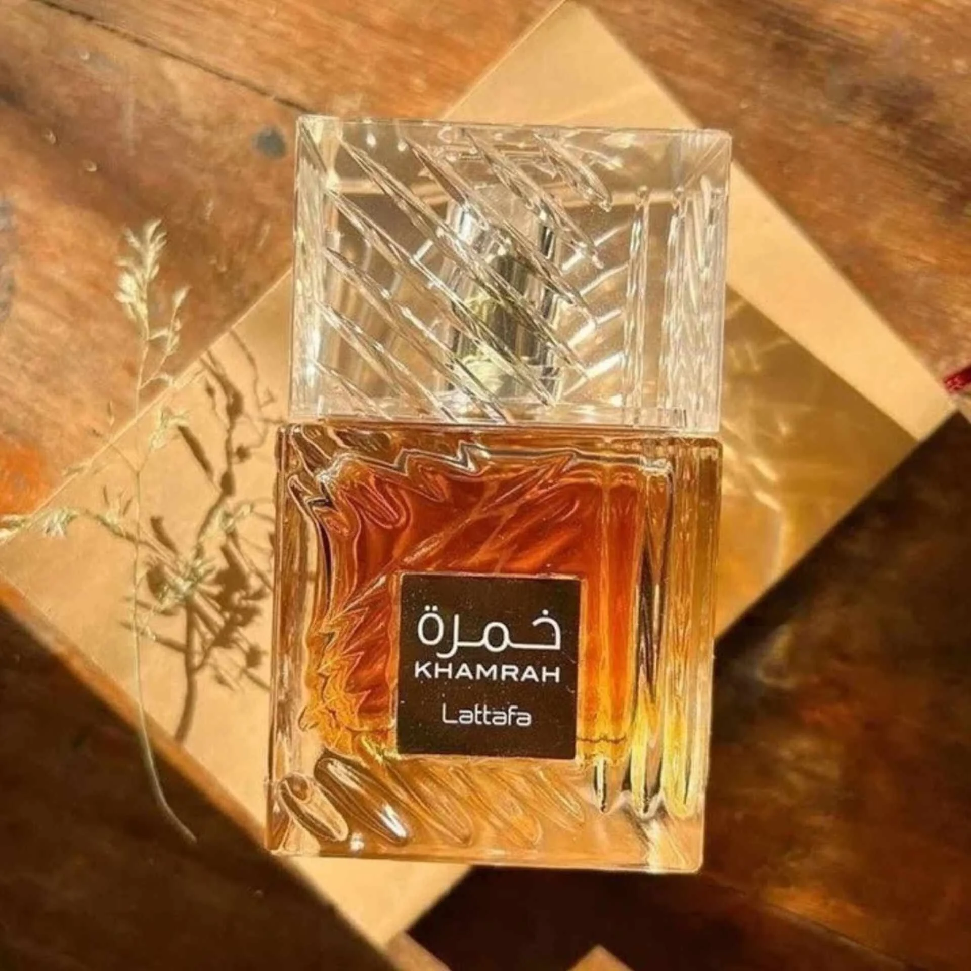 Frasco de perfume KHAMRAH Lattafa em vidro transparente com líquido âmbar