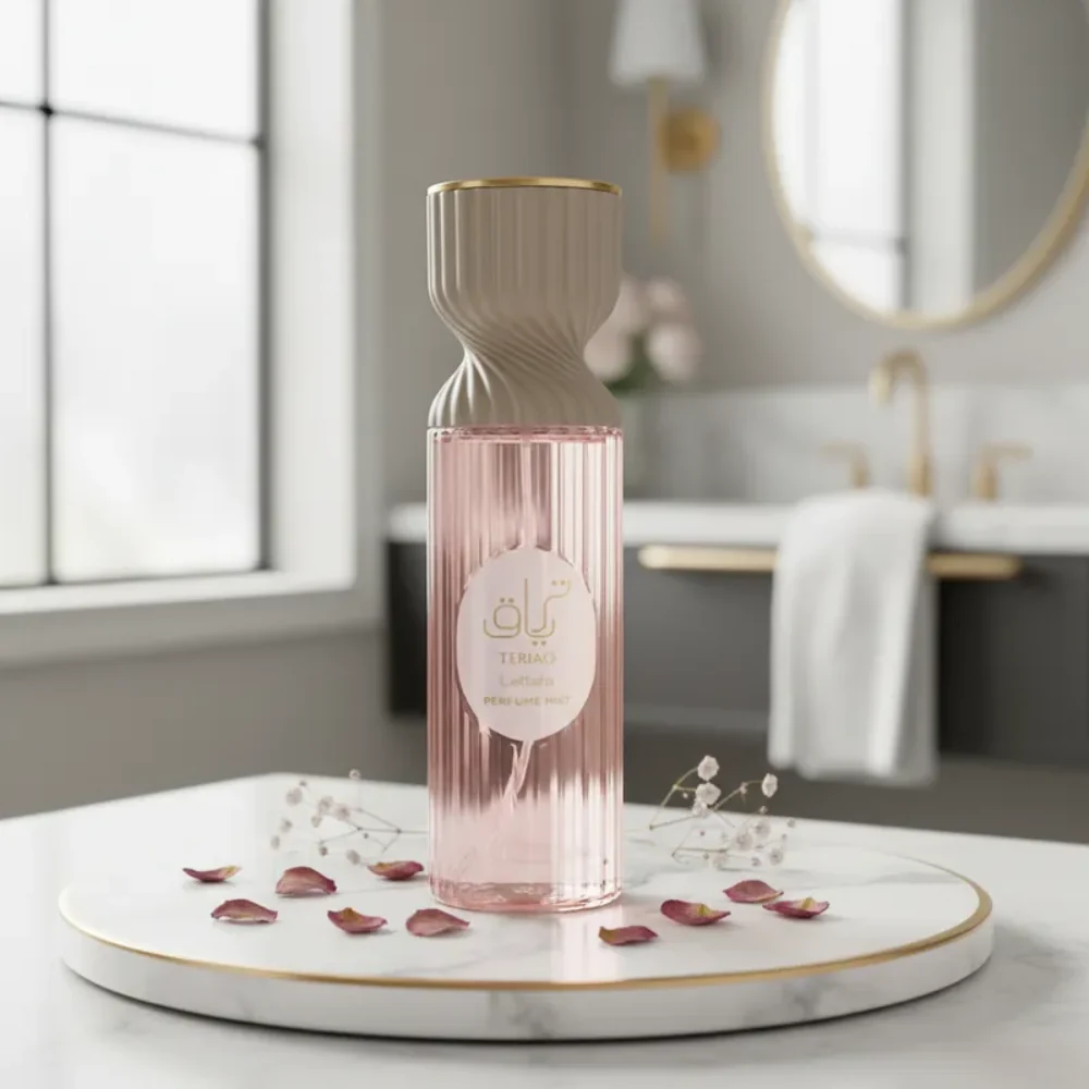 Frasco de perfume rosa com tampa bege e detalhes dourados sobre prato de mármore branco com pétalas e flores em casa de banho