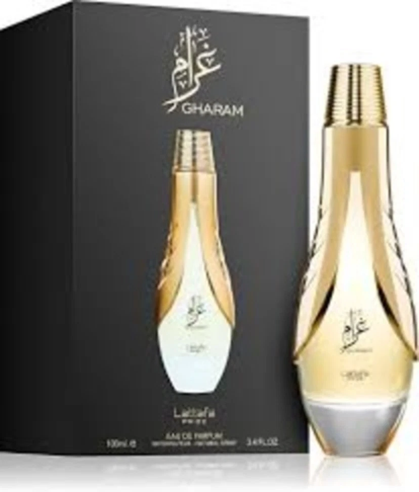 Frasco de perfume dourado com embalagem preta com texto GHARAM
